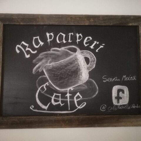 Liitutaulupiirros, kahvikuppi ja teksti Raparperi Cafe sekä ohjeistus seuraamaan kahvilaa facebookissa